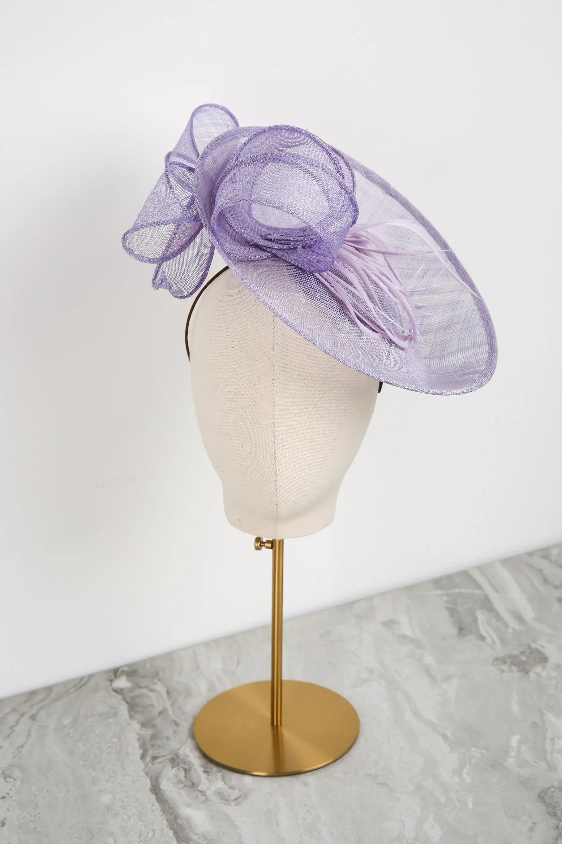 Purple decorative headpiece on a mannequin head against a white background