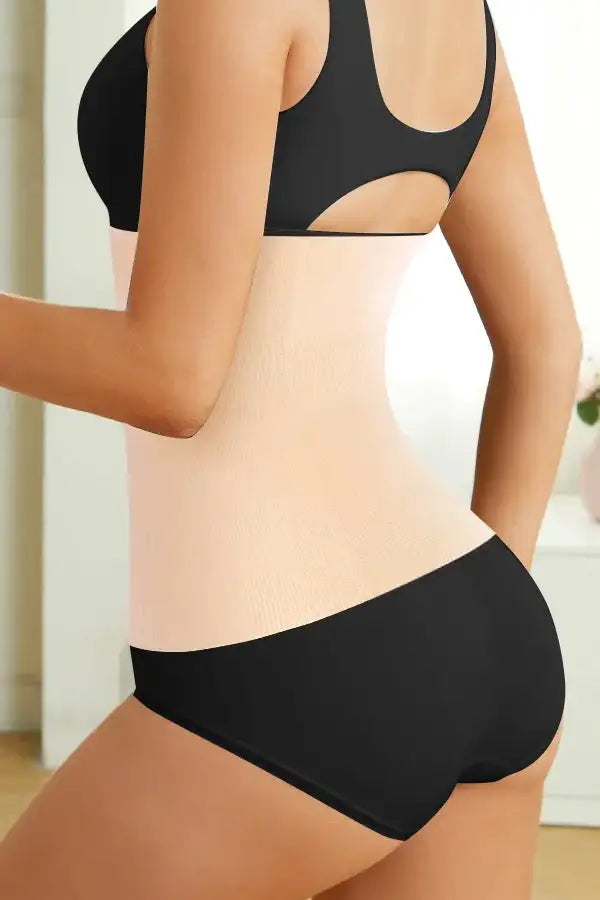 A close-up image of a person wearing a beige waist smoother shapewear, focusing on the waist area showing the smoothing effect.
