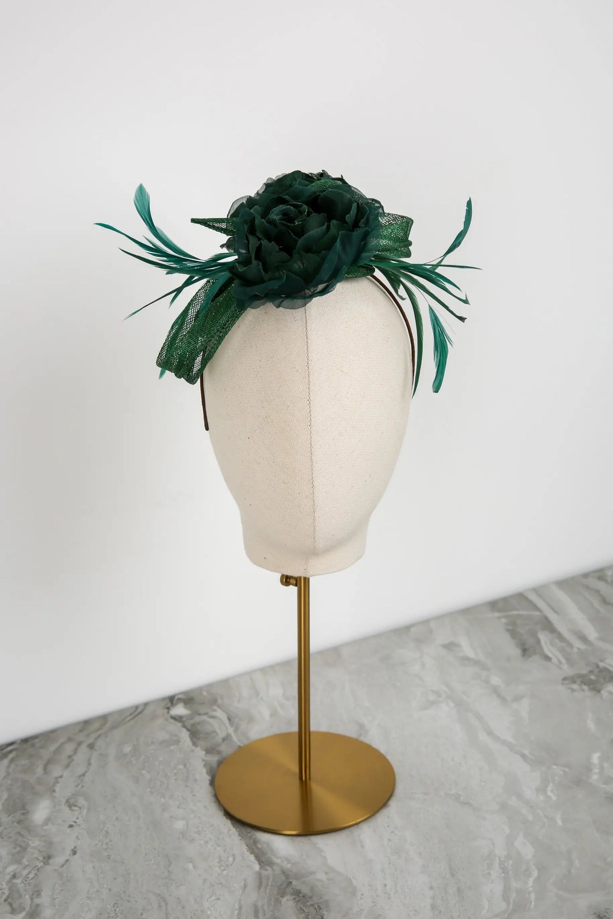 Green floral headpiece on a mannequin head against a white background