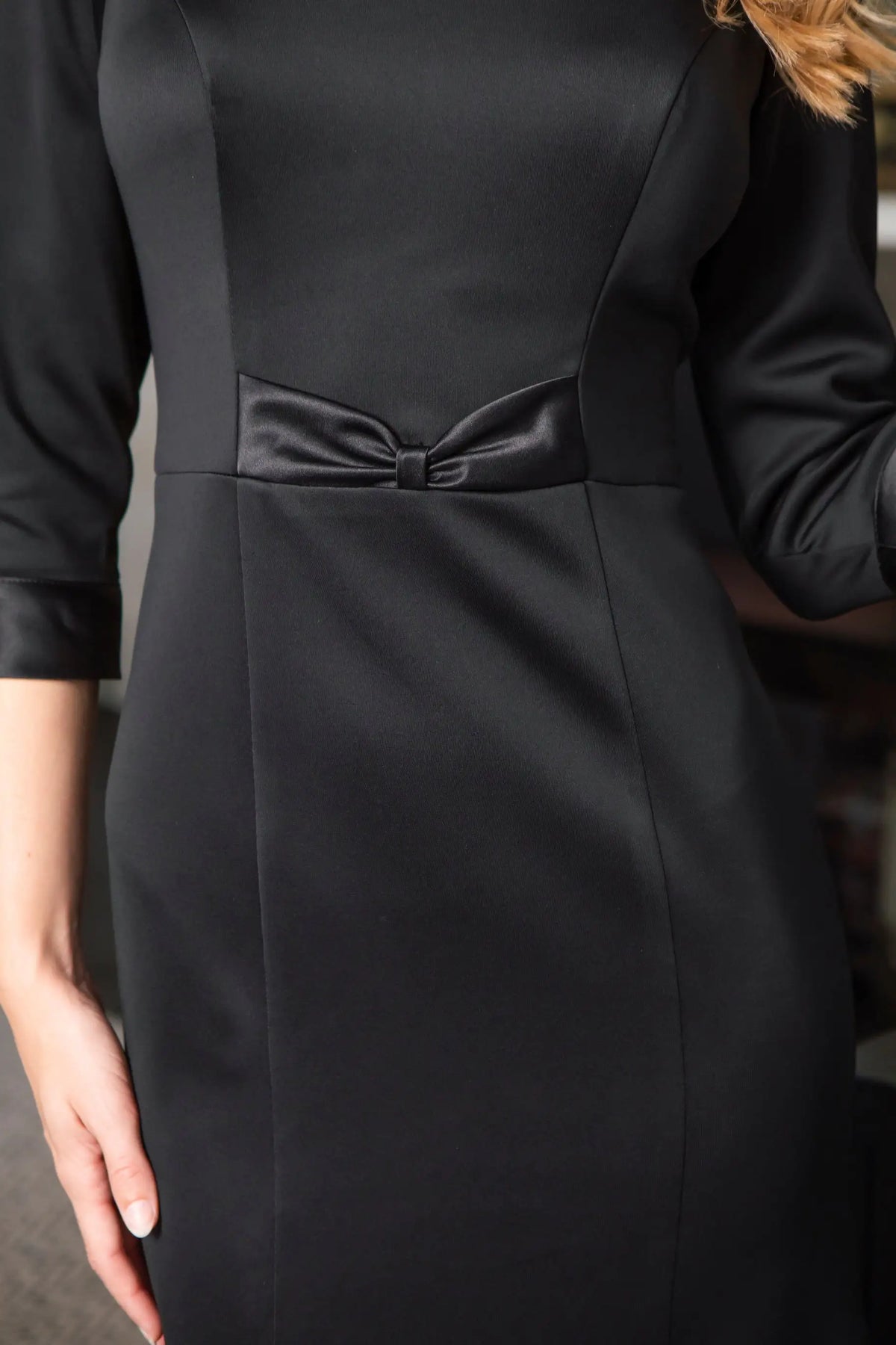 Black dress with a bow detail on a blurred background