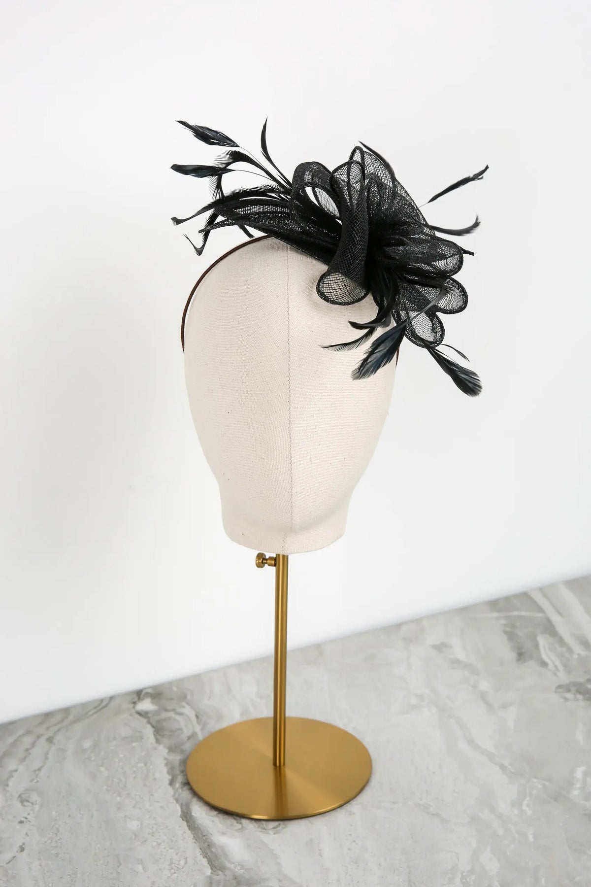 Black decorative headpiece on a mannequin head with a white background