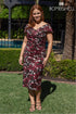 Woman wearing a patterned dress standing outdoors with &