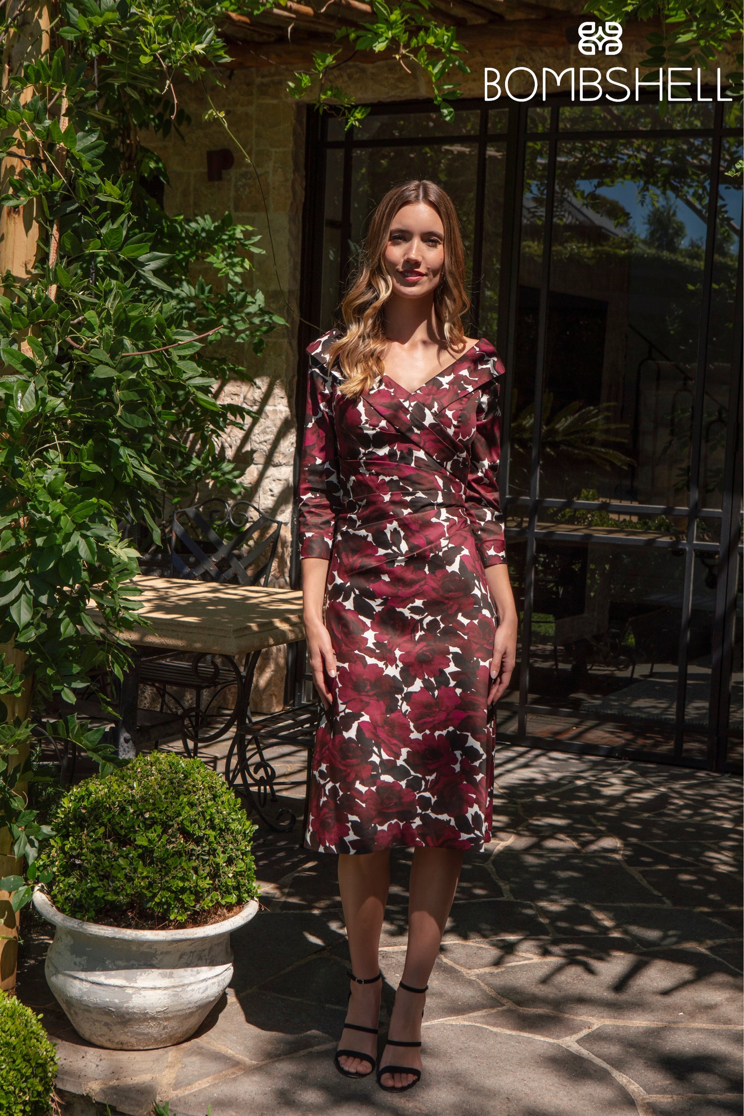 Woman in a floral dress standing outdoors with &