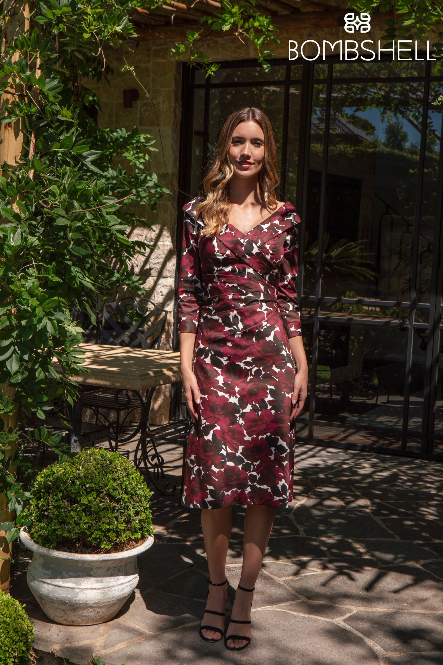Woman in a floral dress standing outdoors with &
