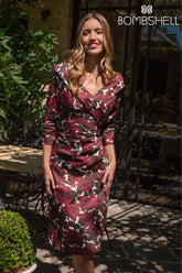 Woman wearing a patterned dress standing outdoors with &