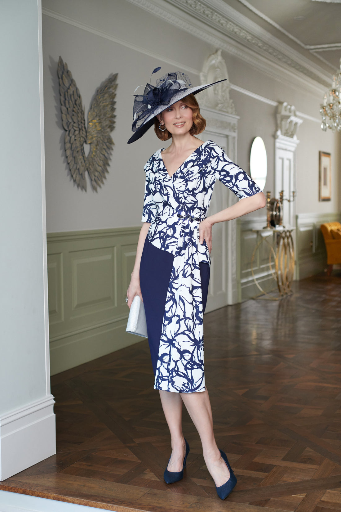 Woman in a blue and white dress with a matching hat in an elegant interior setting