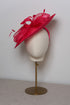 Pink decorative hat on a mannequin head against a plain background