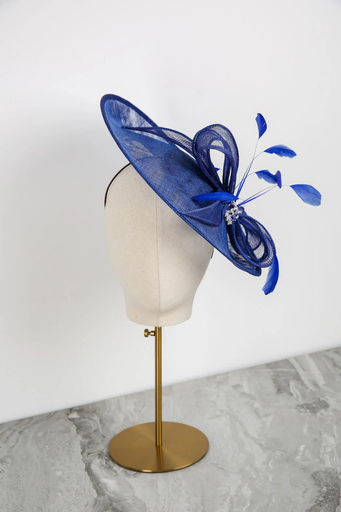 Blue decorative hat on a mannequin head against a white background