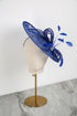 Blue decorative hat on a mannequin head against a white background