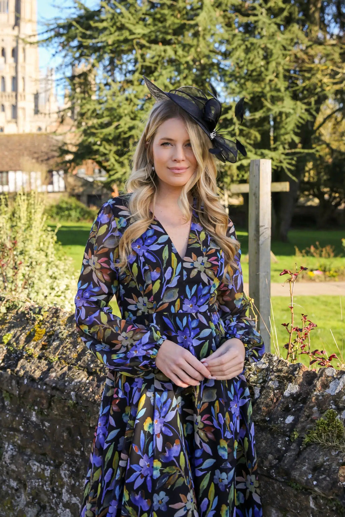 Woman wearing a black fascinator with printed occasion dress