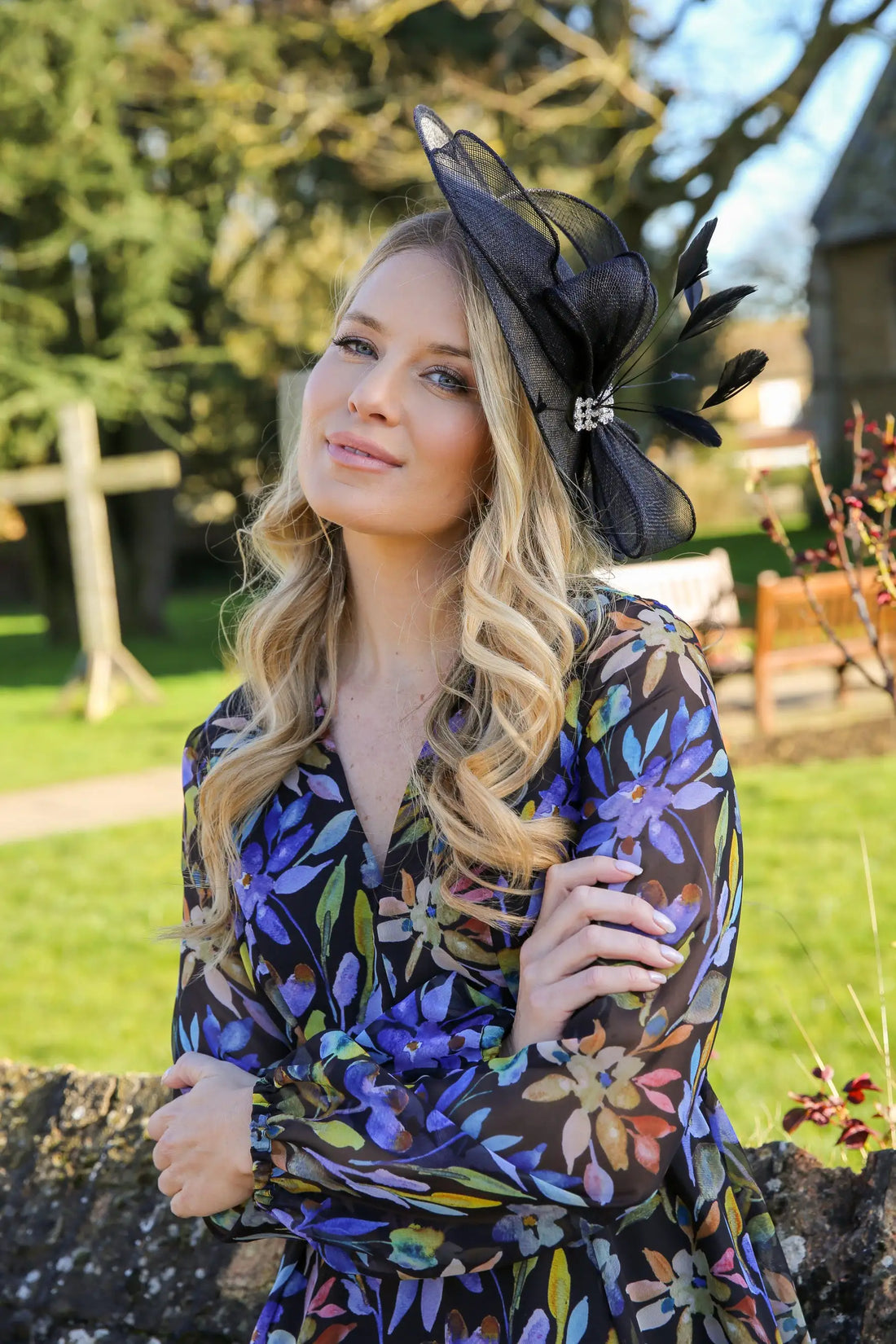 Woman wearing a black fascinator with printed occasion dress