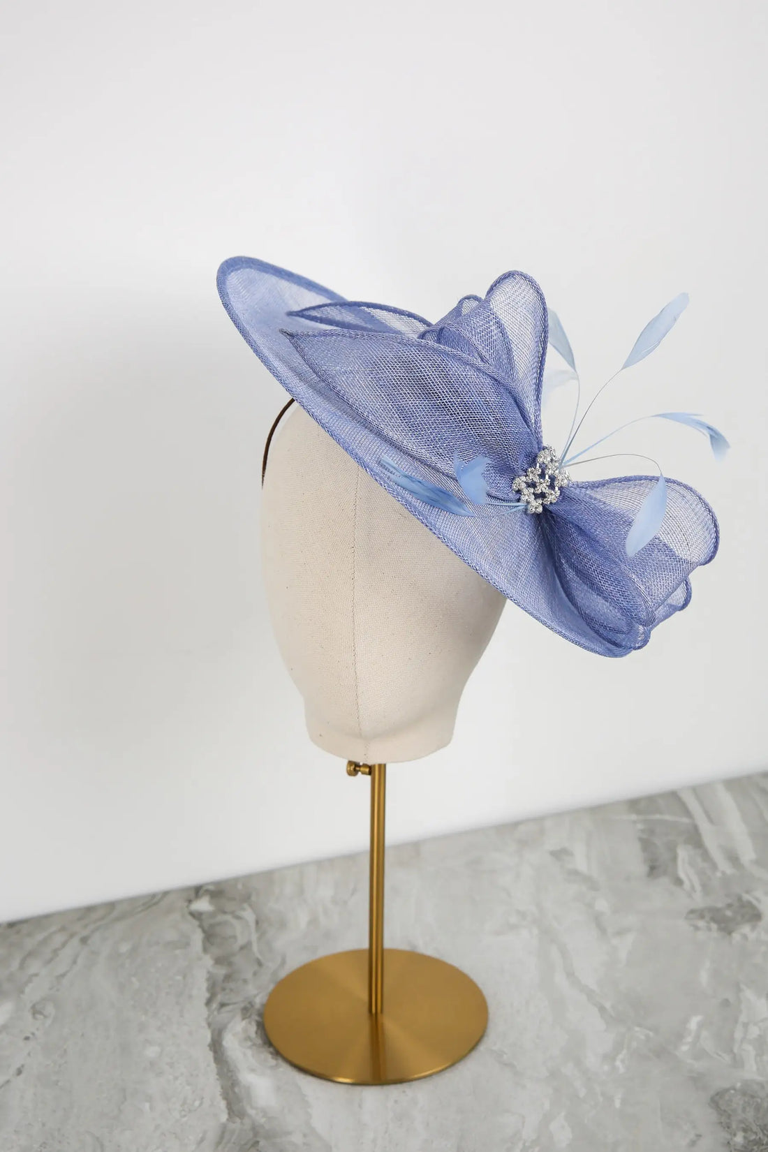 Blue decorative hat on a mannequin head with a white background