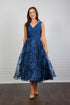 A woman wearing an elegant sleeveless midi length dress with a v-neck and fully lined embroidered skirt in Oxford Blue.
