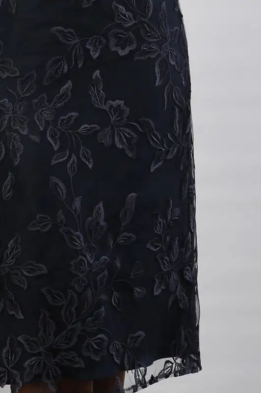 A woman wearing a cream and navy midi dress.