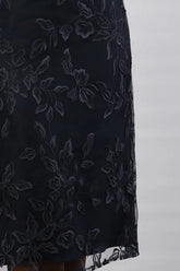 A woman wearing a cream and navy midi dress.