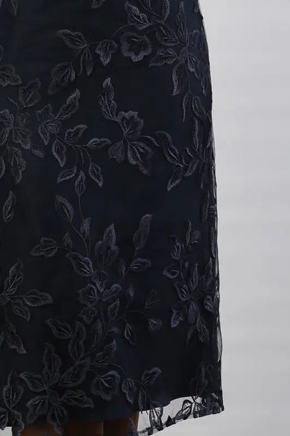 A woman wearing a cream and navy midi dress.