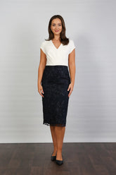 A woman wearing a cream and navy midi dress.