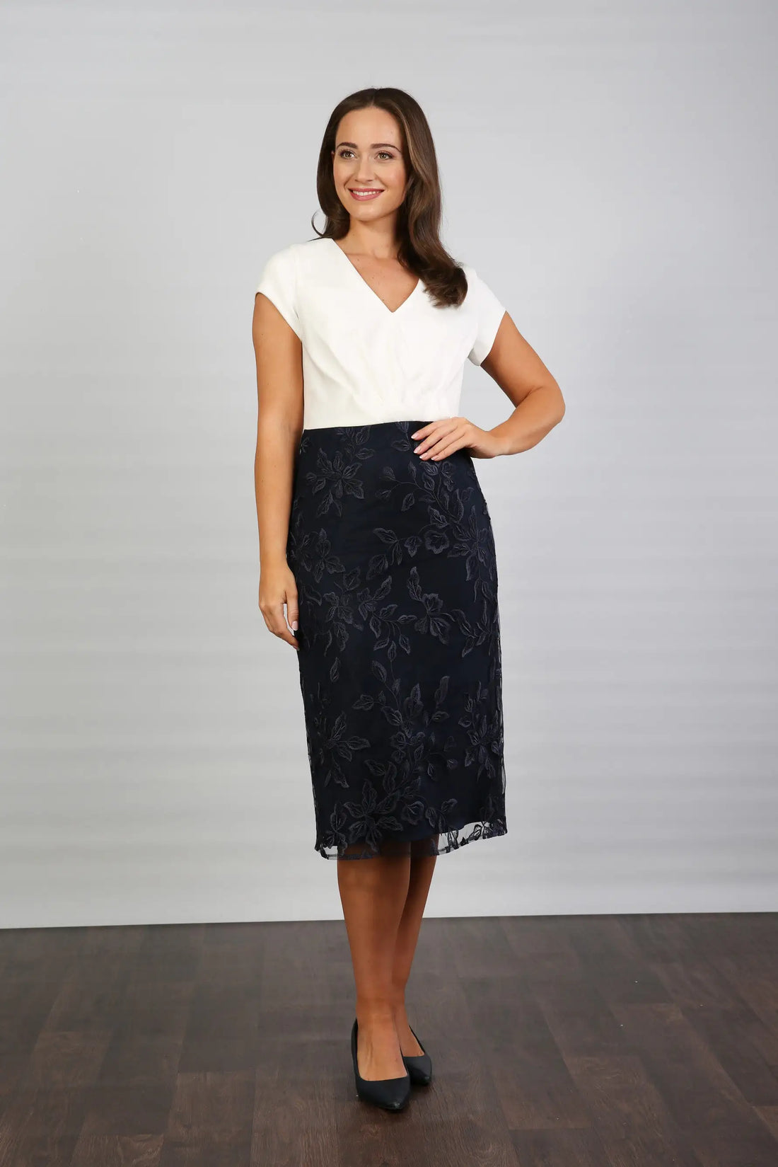 A woman wearing a cream and navy midi dress.