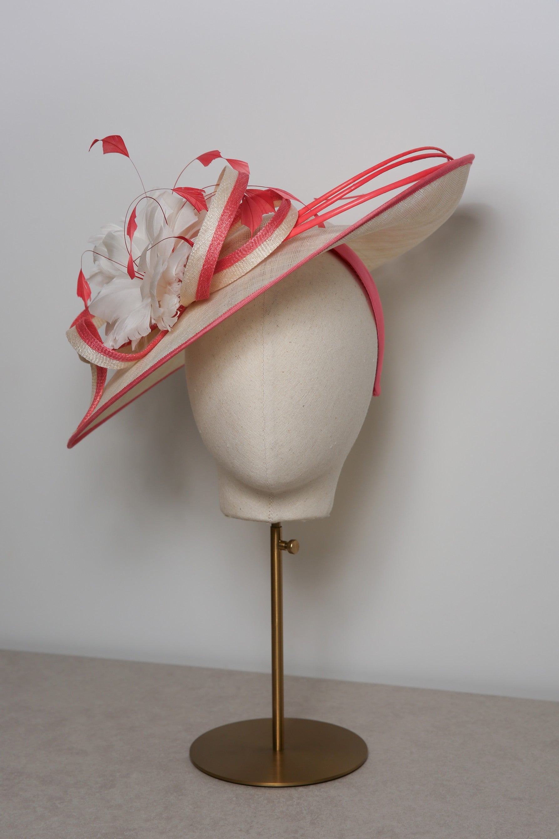 Decorative hat on a mannequin head with a plain background