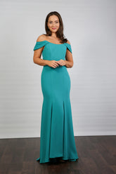 A woman in an off-the-shoulder turquoise maxi dress with a fit and flare silhouette, made from crepe fabric, posed against a neutral background.