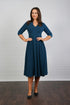 A model wearing a midi-length blue crepe dress with a V-neck, 3/4 sleeves, and a fitted waist.