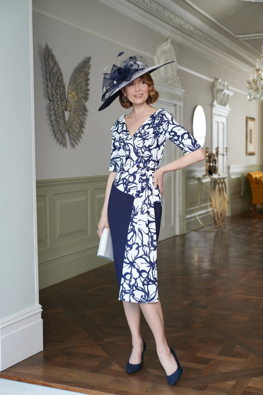 Woman in a blue and white dress with a matching hat in an elegant interior setting