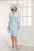 Woman wearing a light blue dress and jacket set with a matching hat in a bright room.