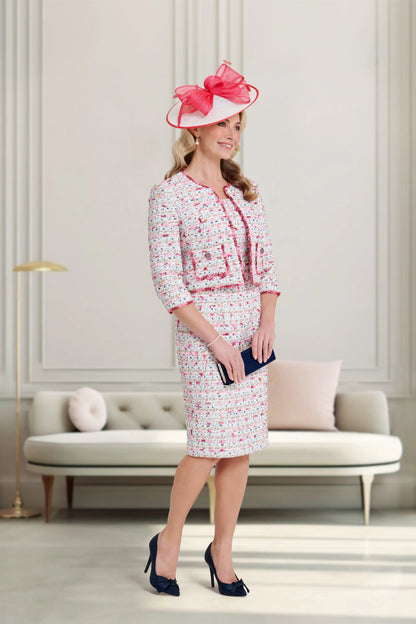 Woman in a stylish outfit with a pink hat in an elegant room.