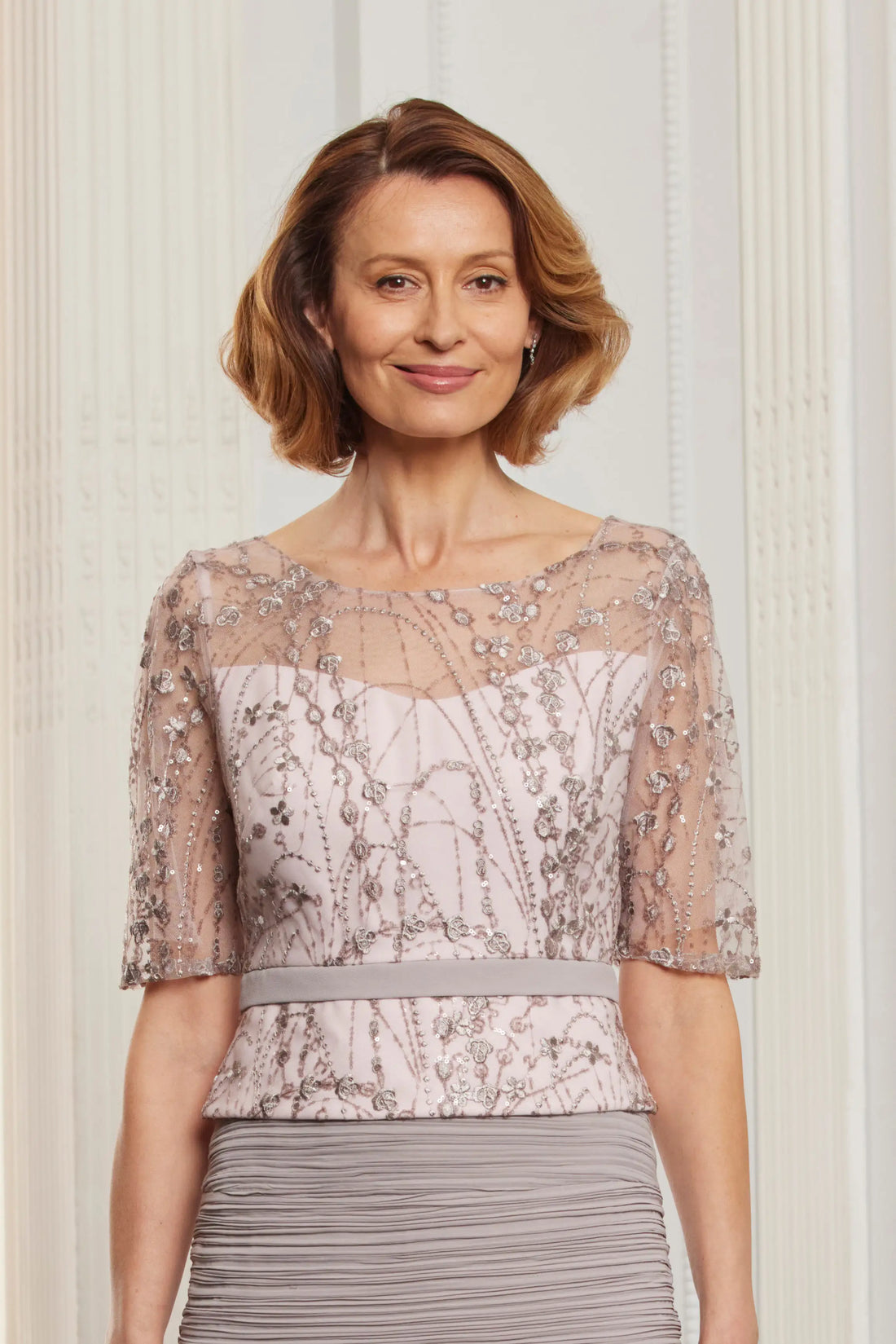 Woman wearing a patterned top with a neutral background