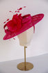 Fuchsia pink hat with floral details on a mannequin head against a white background