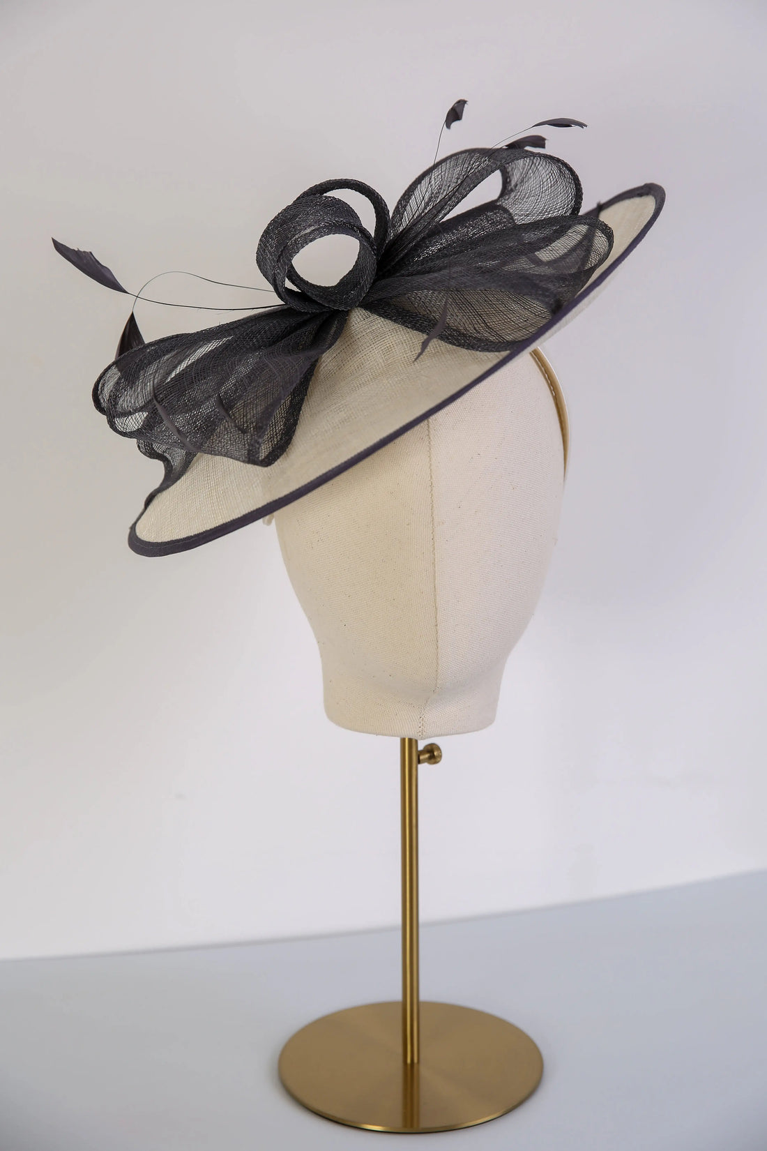 Cream decorative hat with a navy trim. 