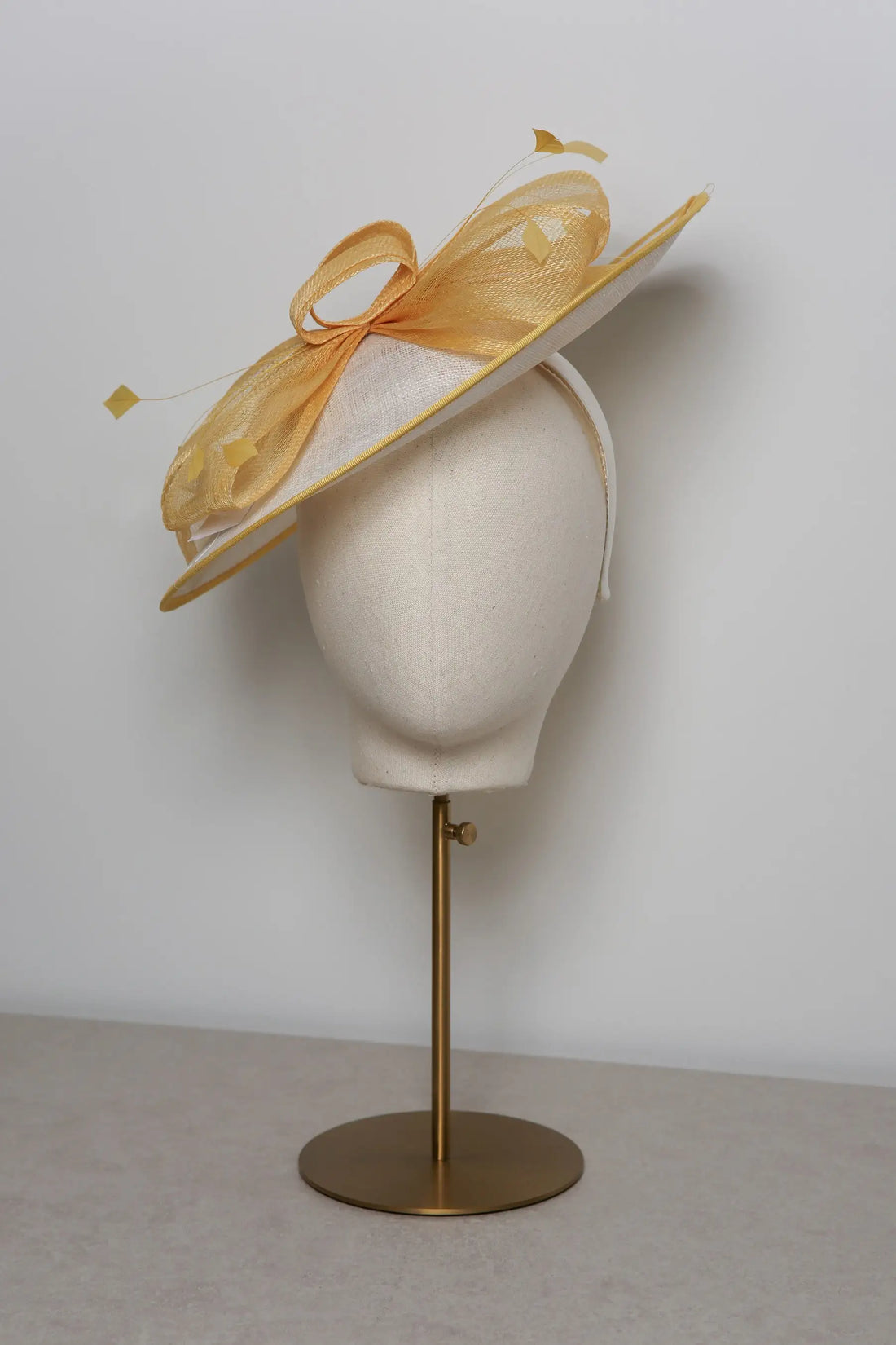 Yellow hat on a mannequin head with a white background