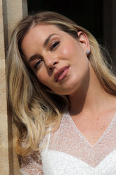 A pair of crystal halo stud earrings, with the earrings themselves having a large central clear crystal surrounded by smaller clear crystals.