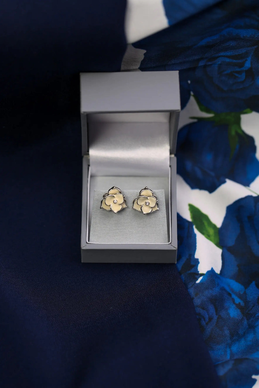 Floral earrings in a box on a floral fabric background