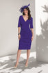 Woman wearing a purple dress with a matching headpiece against a white background