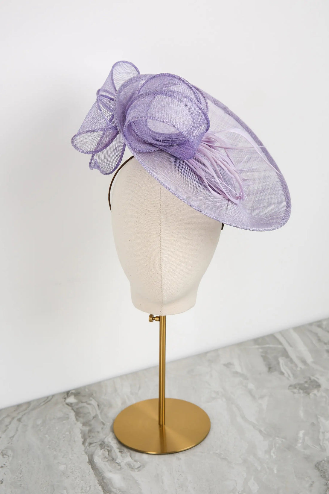 Purple decorative headpiece on a mannequin head against a white background
