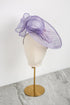 Purple decorative headpiece on a mannequin head against a white background