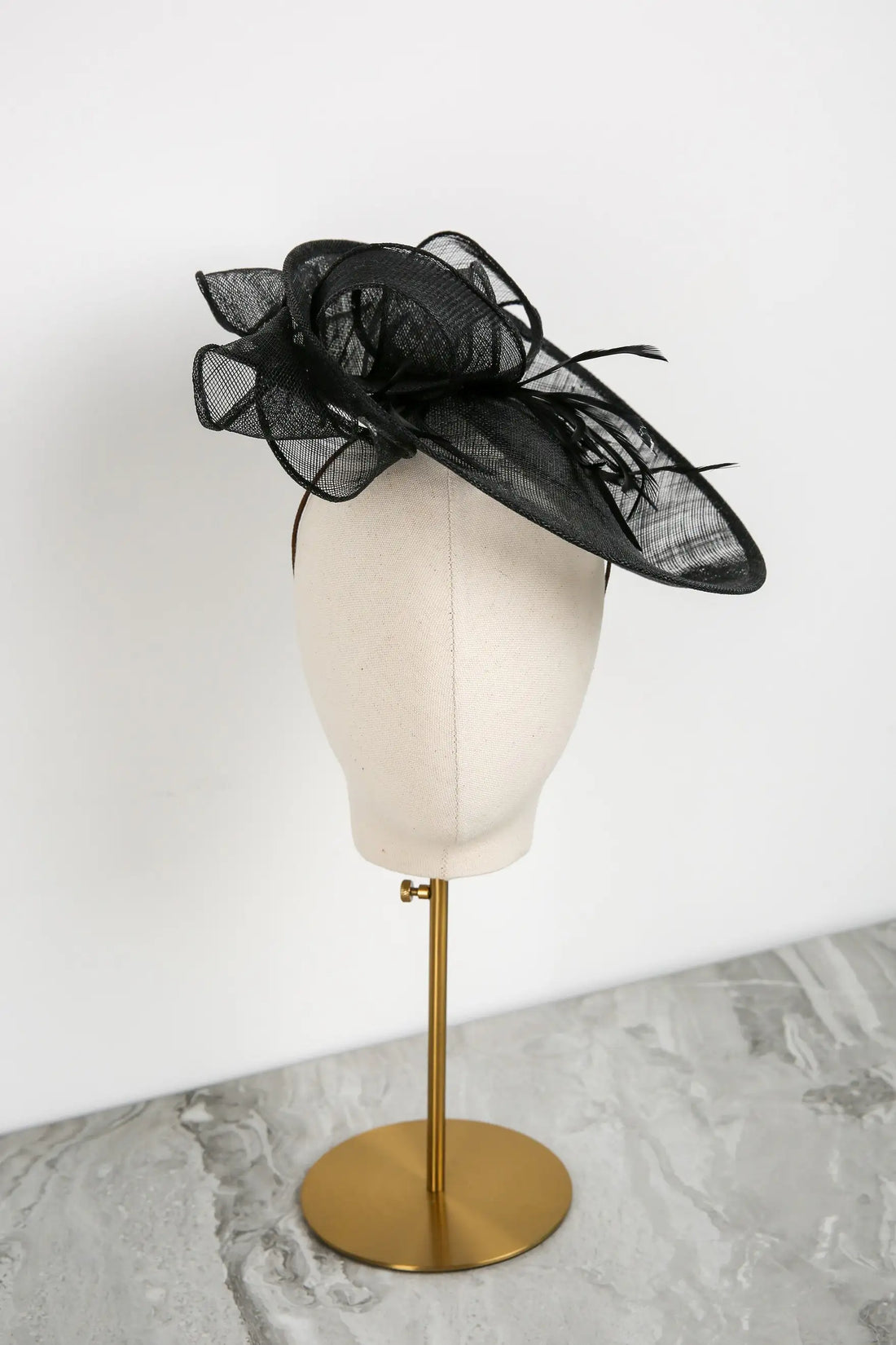 Black decorative hat on a mannequin head with a white background