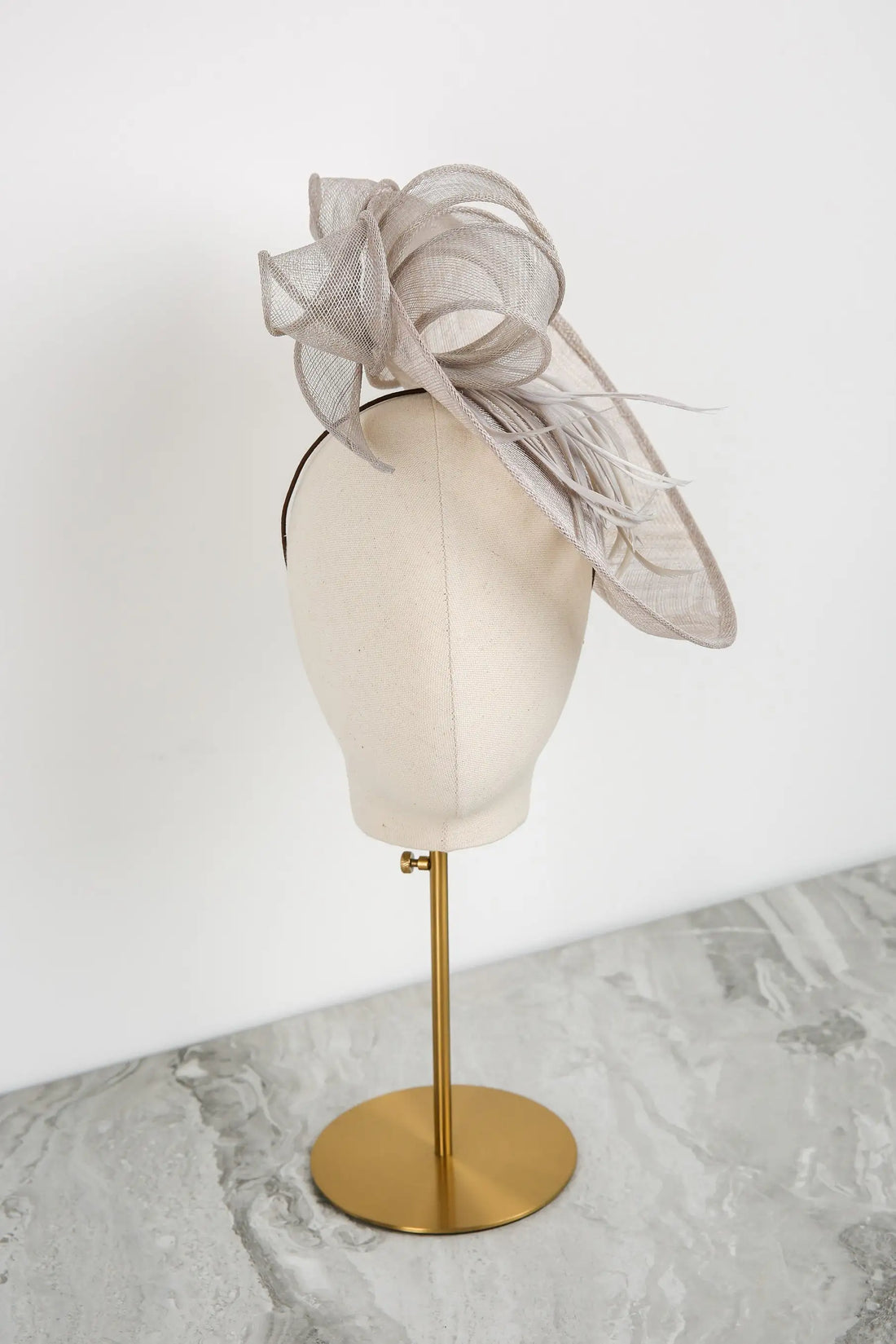 Silver fascinator on a mannequin head against a white background
