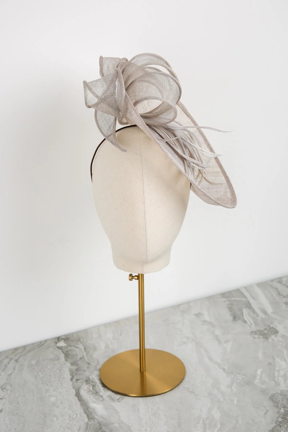Silver fascinator on a mannequin head against a white background