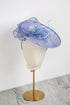 Blue decorative hat on a mannequin head against a white background