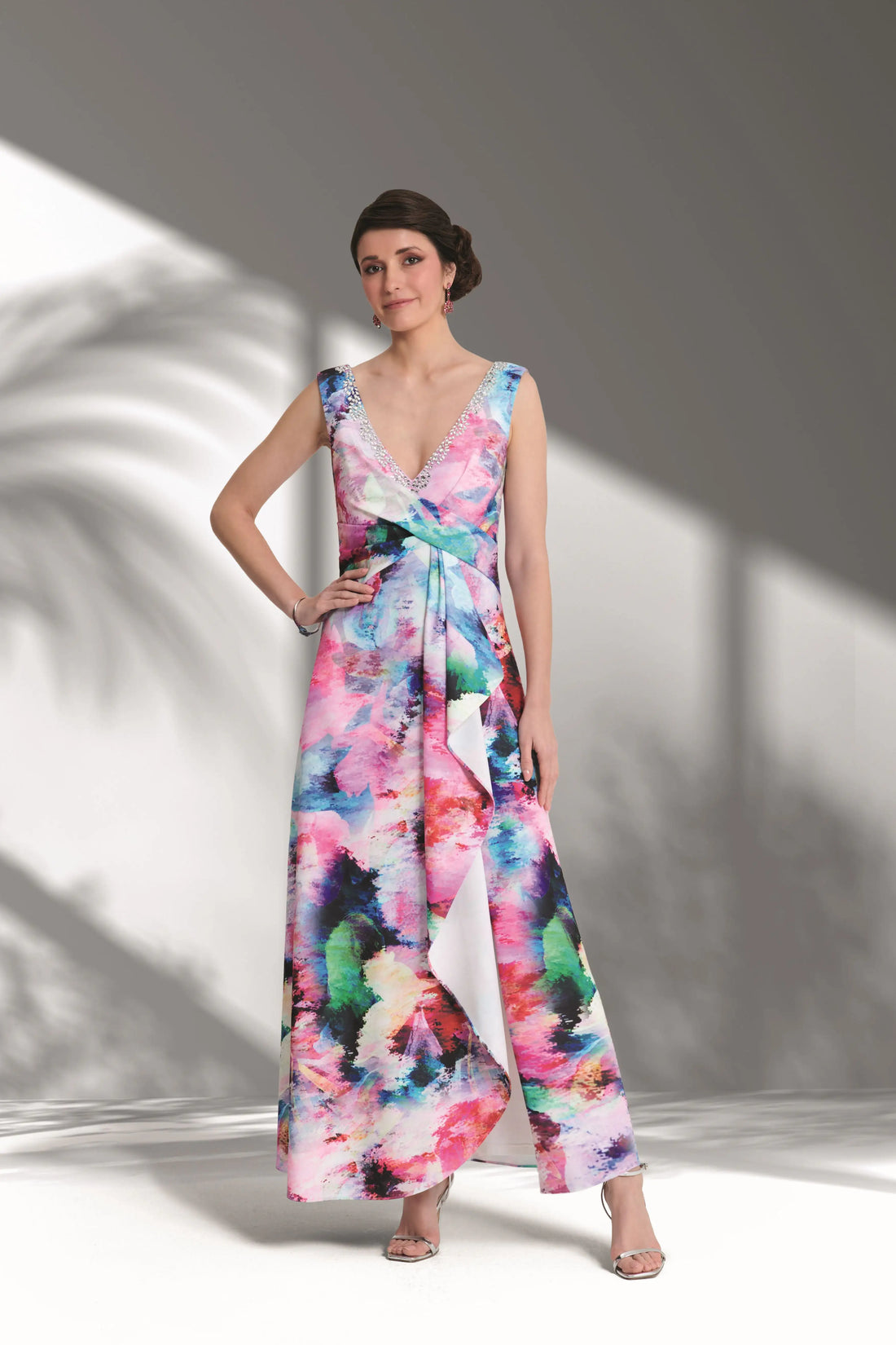 Woman wearing a colourful floral dress against a white background
