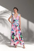 Woman wearing a colourful floral dress against a white background