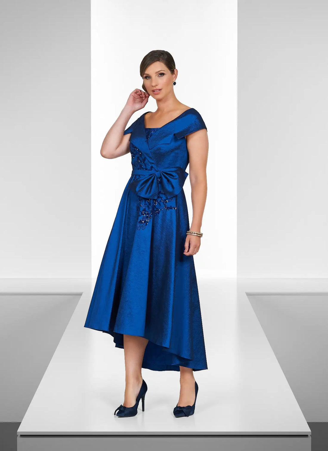 Woman wearing a blue dress on a white platform