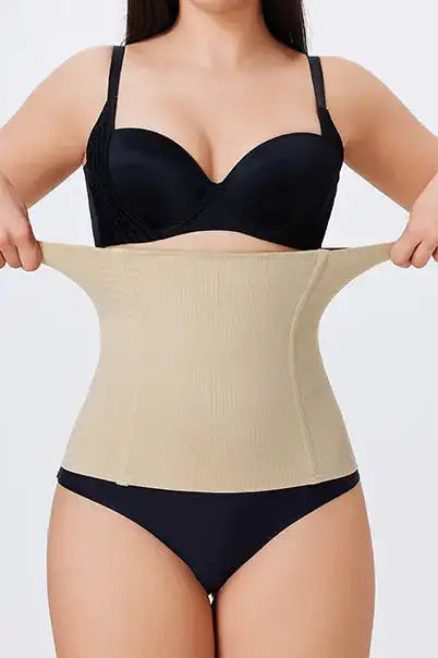 A close-up image of a person wearing a beige waist smoother shapewear, focusing on the waist area showing the smoothing effect.
