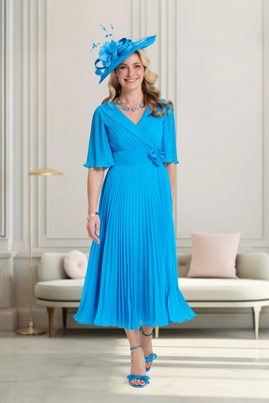 Woman wearing a blue dress and hat in an elegant room.