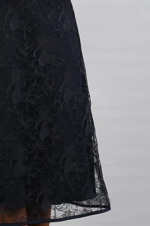 A woman in a Satin and Lace Navy occasion dress.