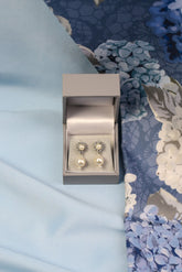 A close-up image of pearl diamante flower drop earrings.
