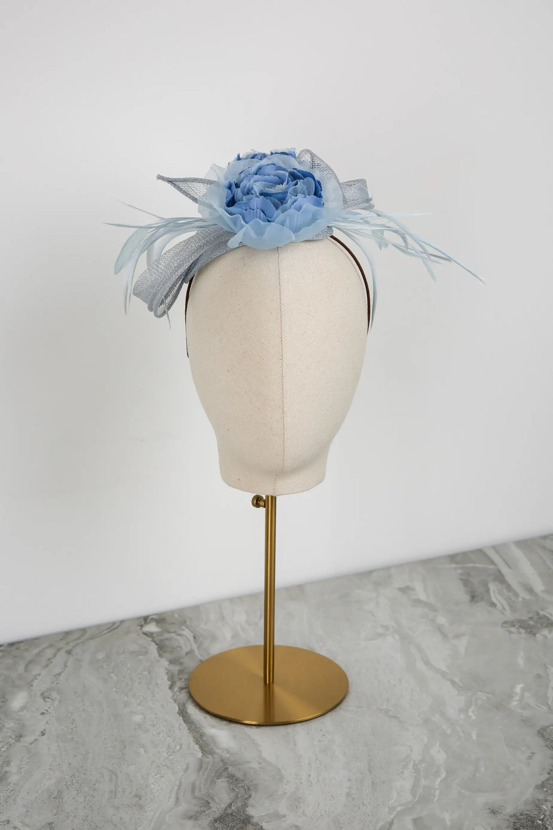 Blue floral headpiece on a mannequin head against a white background