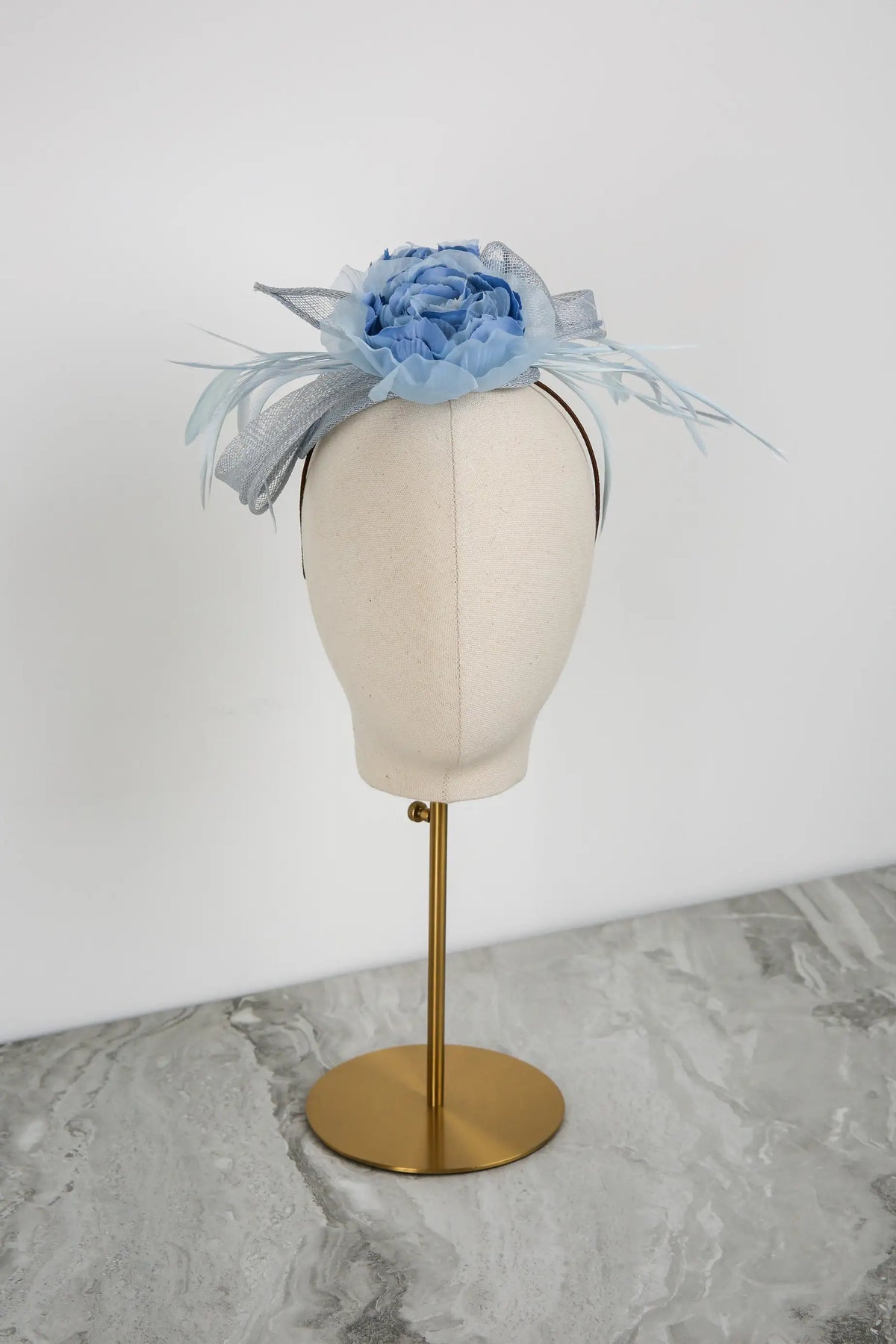 Blue floral headpiece on a mannequin head against a white background
